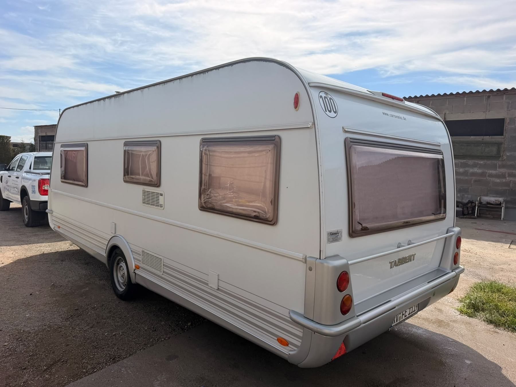Rear of a white Tabbert caravan parked in a yard