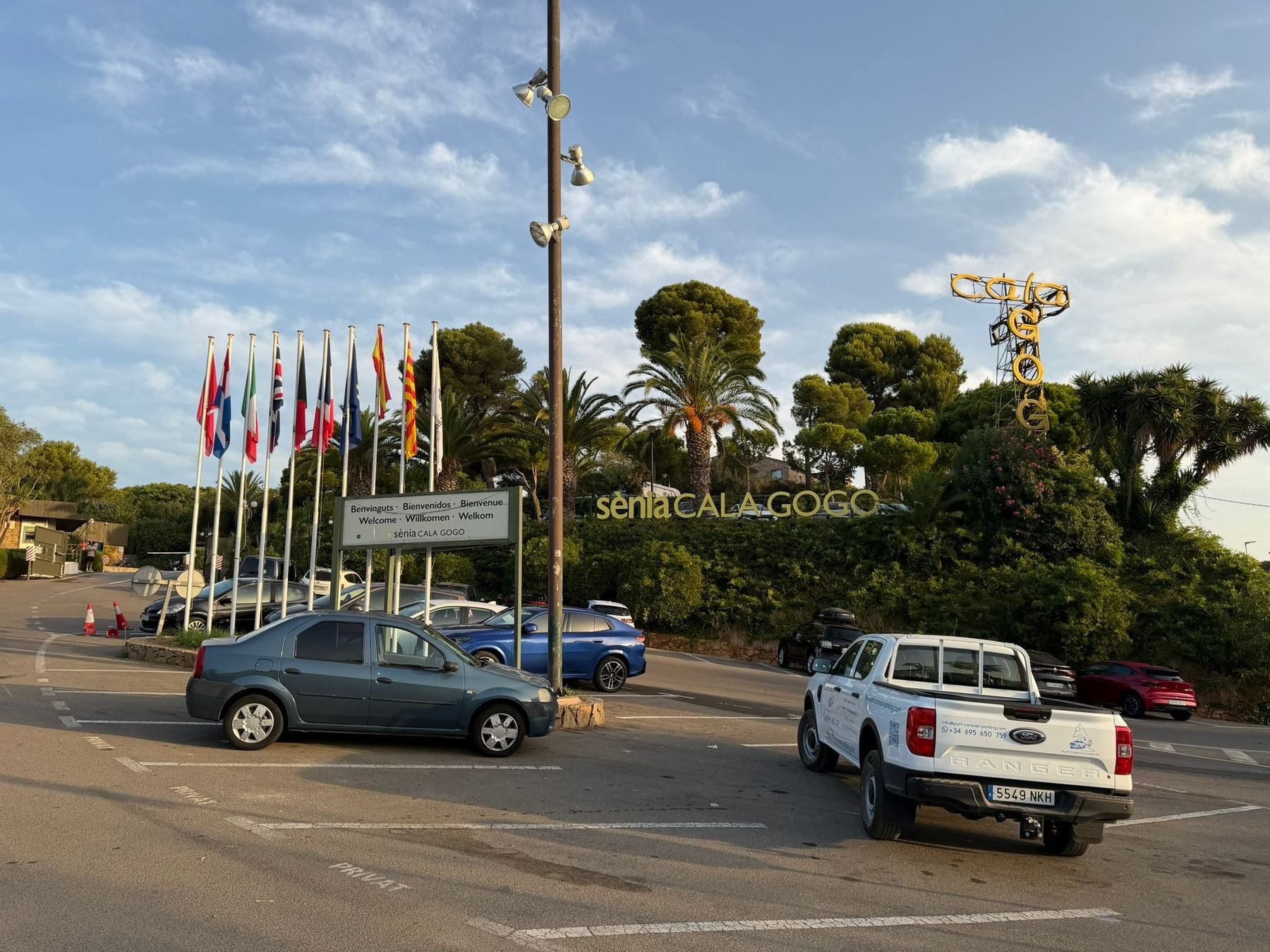 Punt pickup at a campsite entrance lined with flags