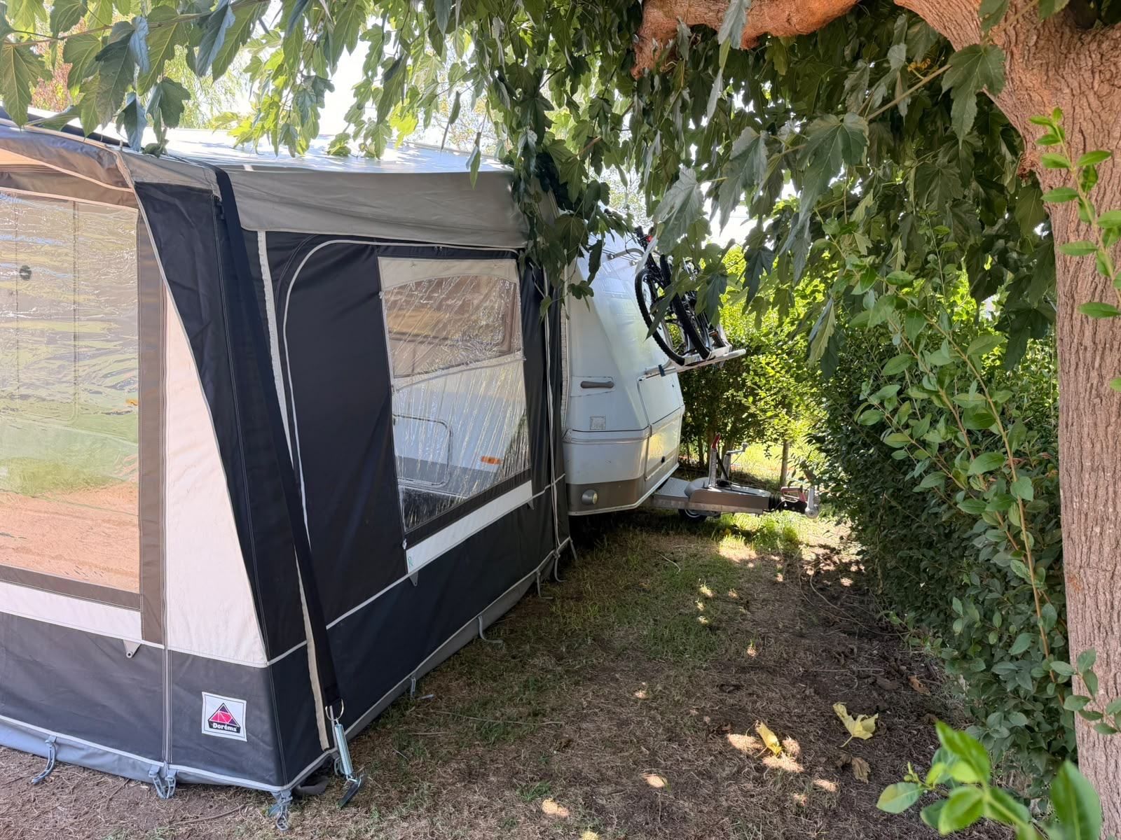 Side of a caravan awning under the trees