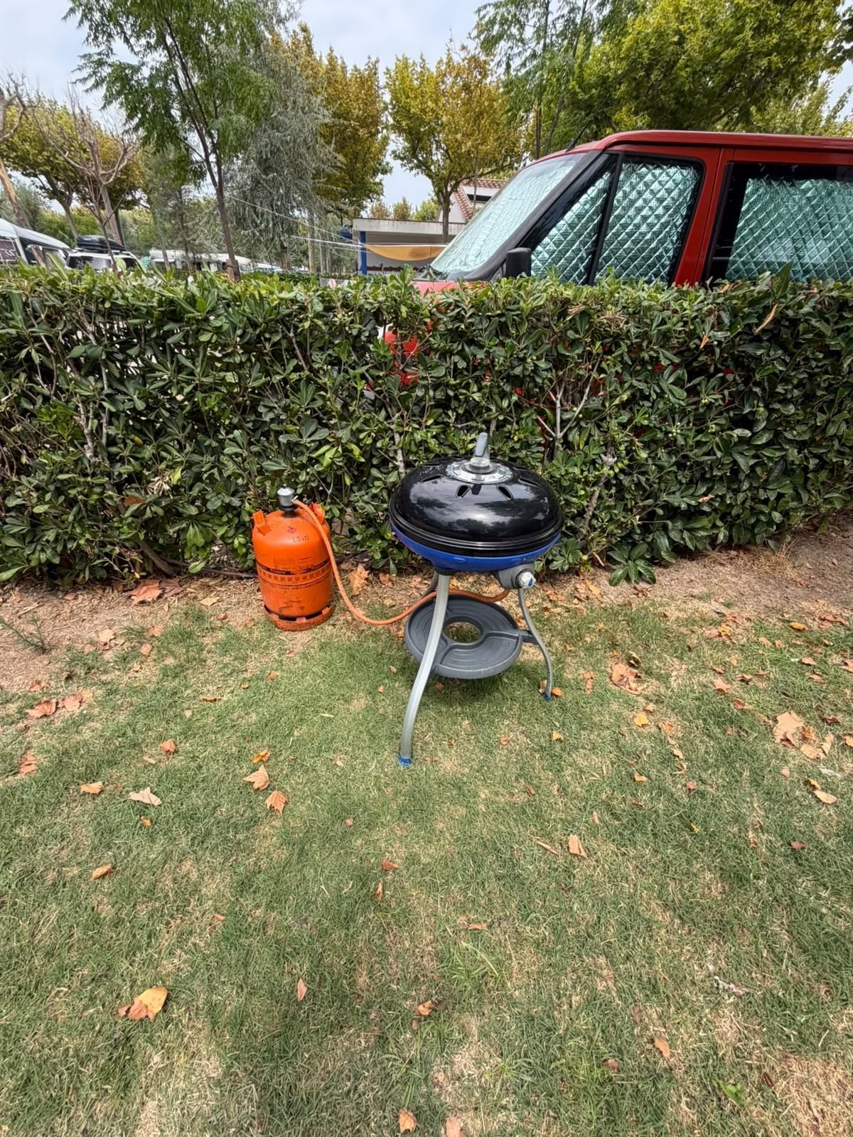 Barbecue and gas bottle on the lawn of a pitch
