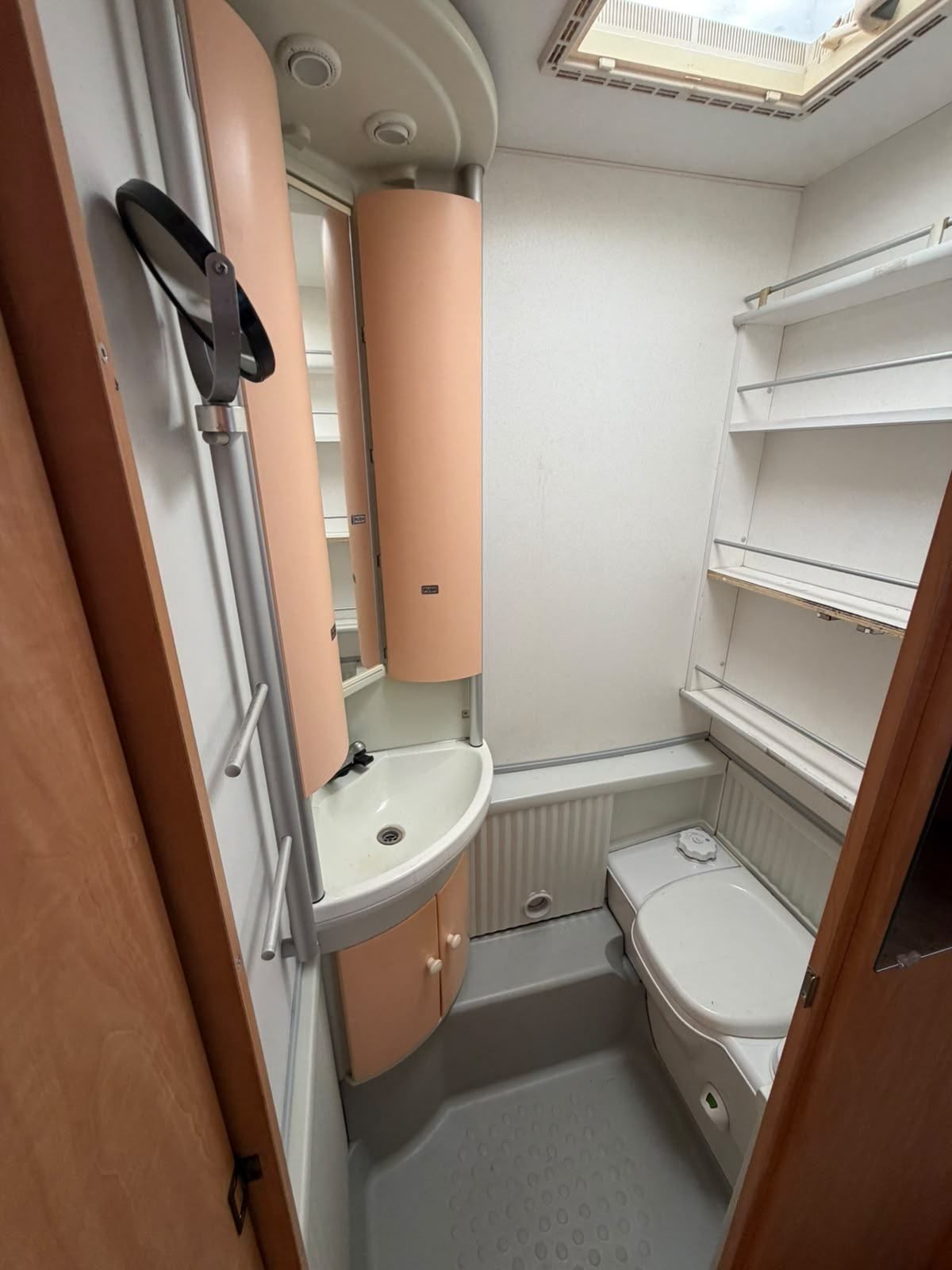 Caravan bathroom with toilet, basin and shelves