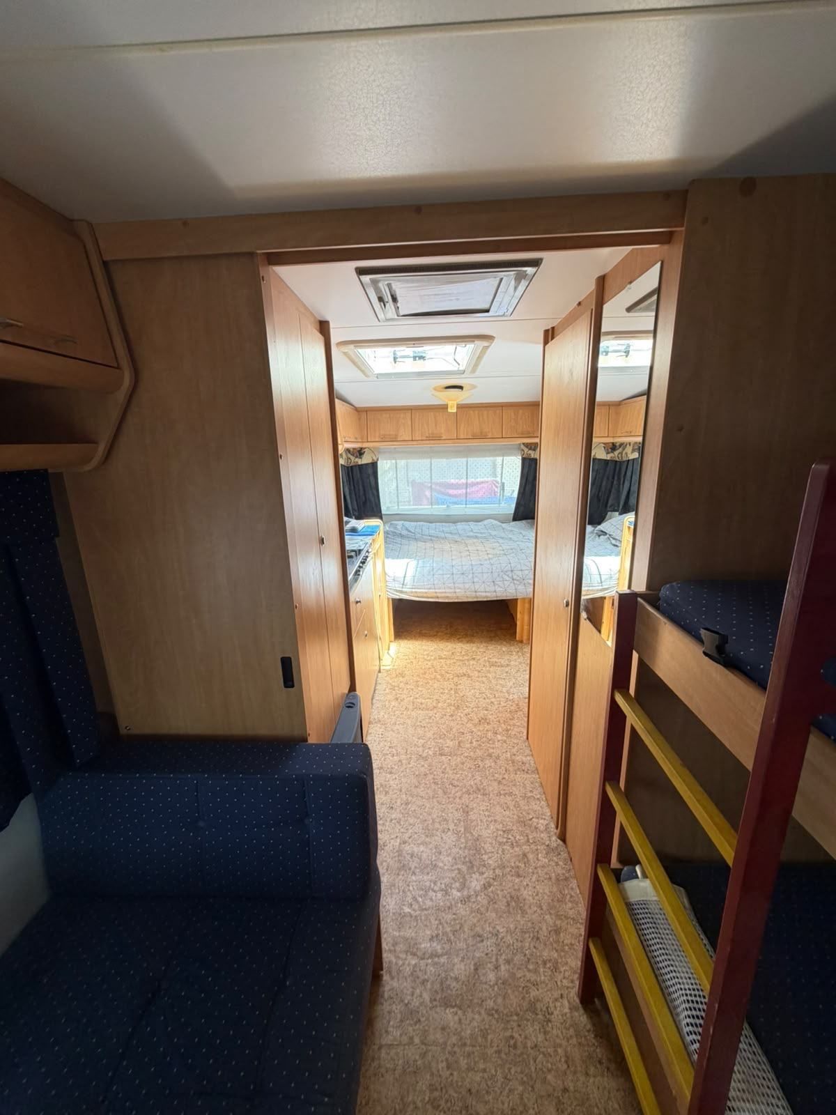 View through a caravan to the rear bedroom past the bunk beds