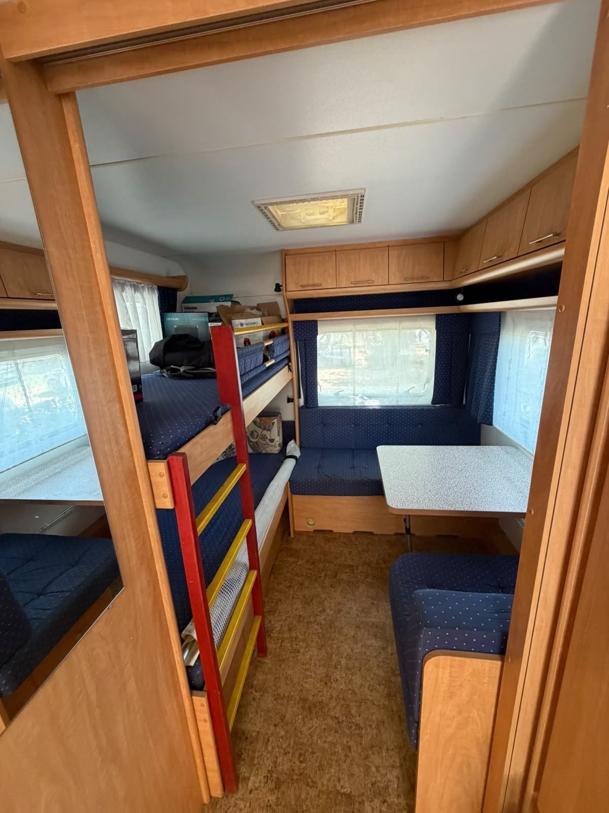 Caravan with bunk beds and a blue dinette