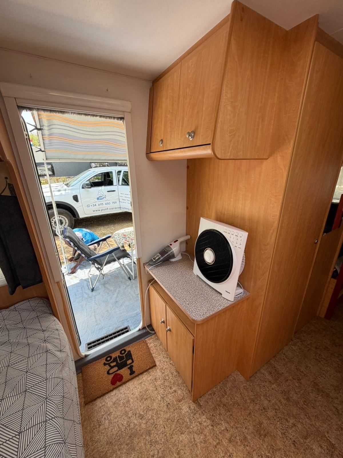 View from inside a caravan through the open door to the Punt pickup outside