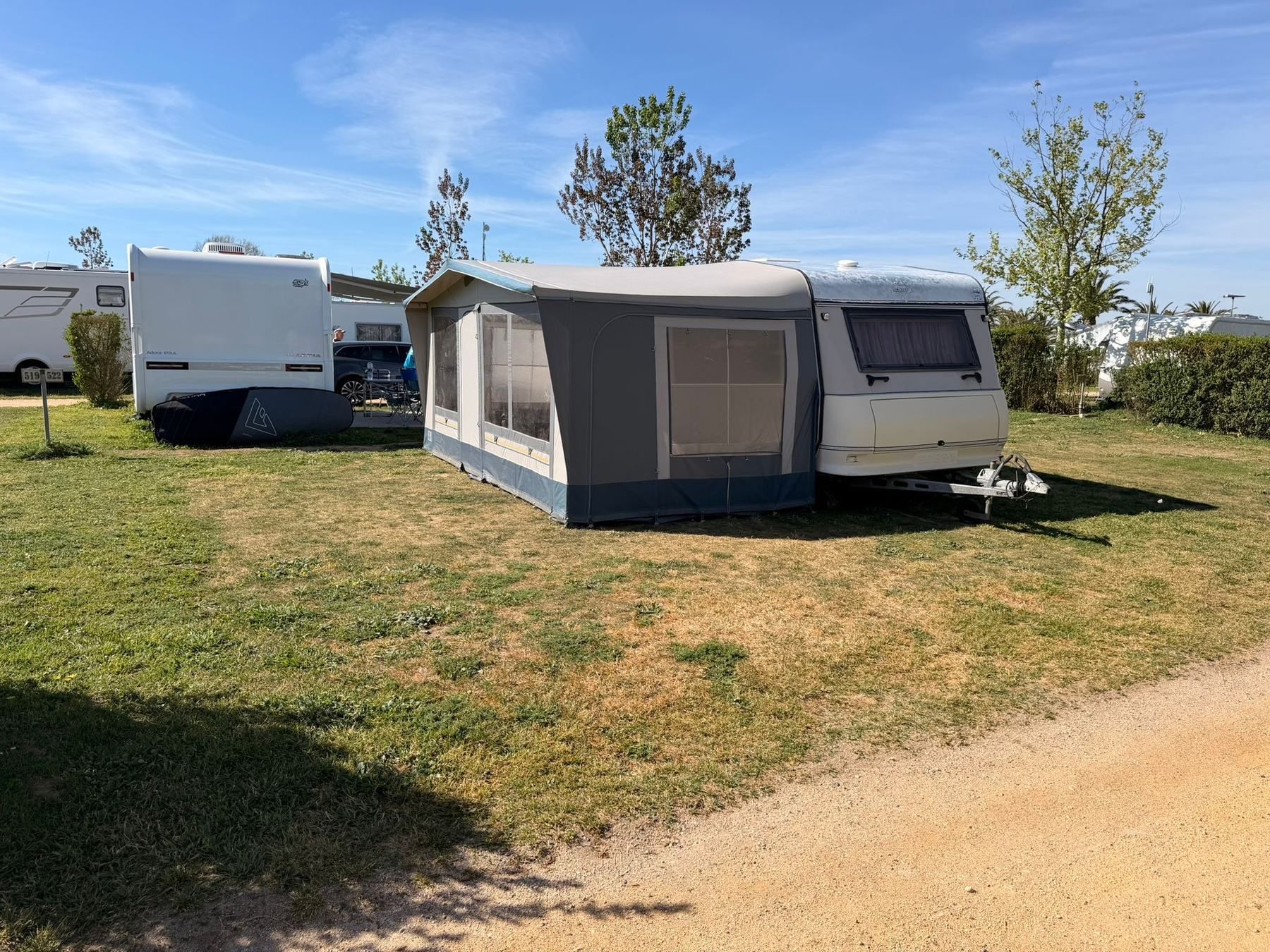 Caravan with a full awning set up on a grassy pitch