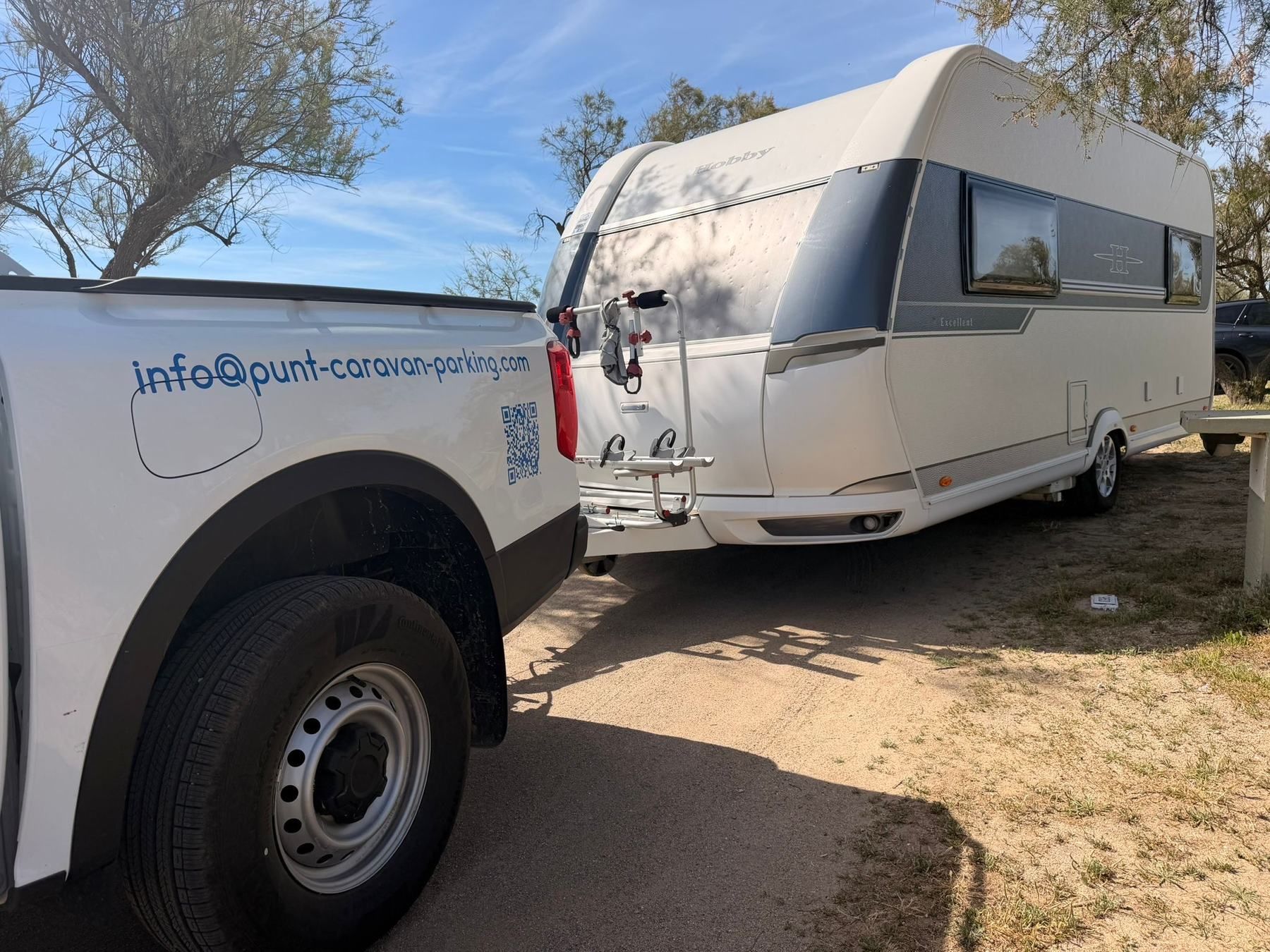 Punt pickup with the email address on the side, hitched to a Hobby caravan