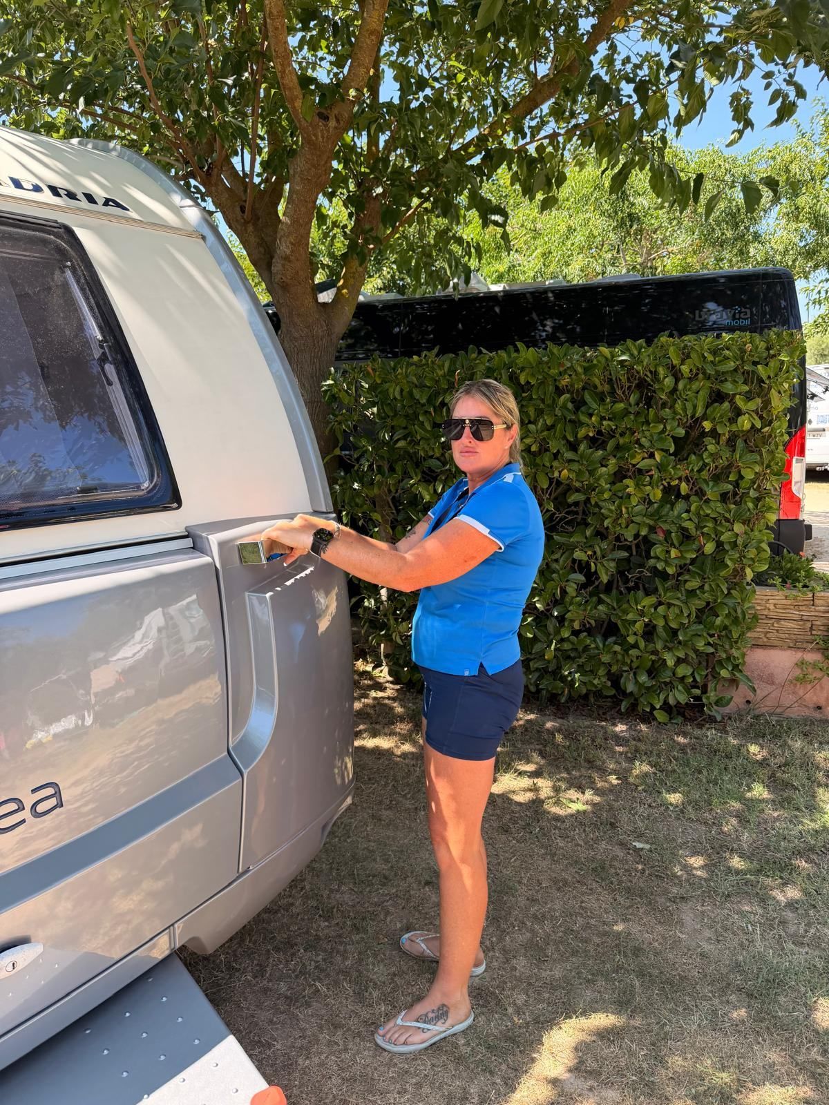 Team member opening the door of a caravan on its pitch