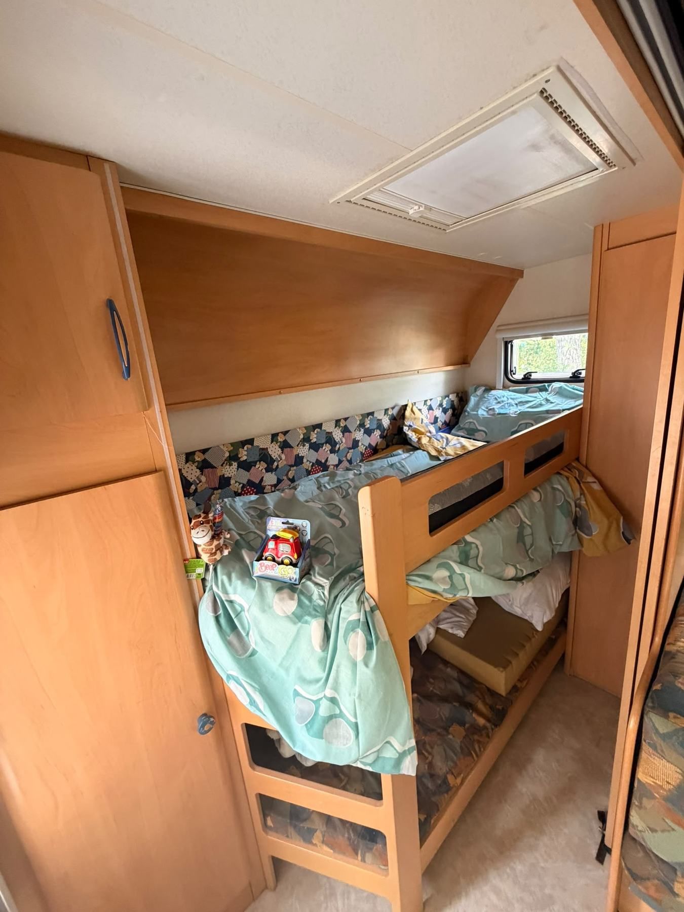 Bunk beds inside a caravan with wooden wardrobes