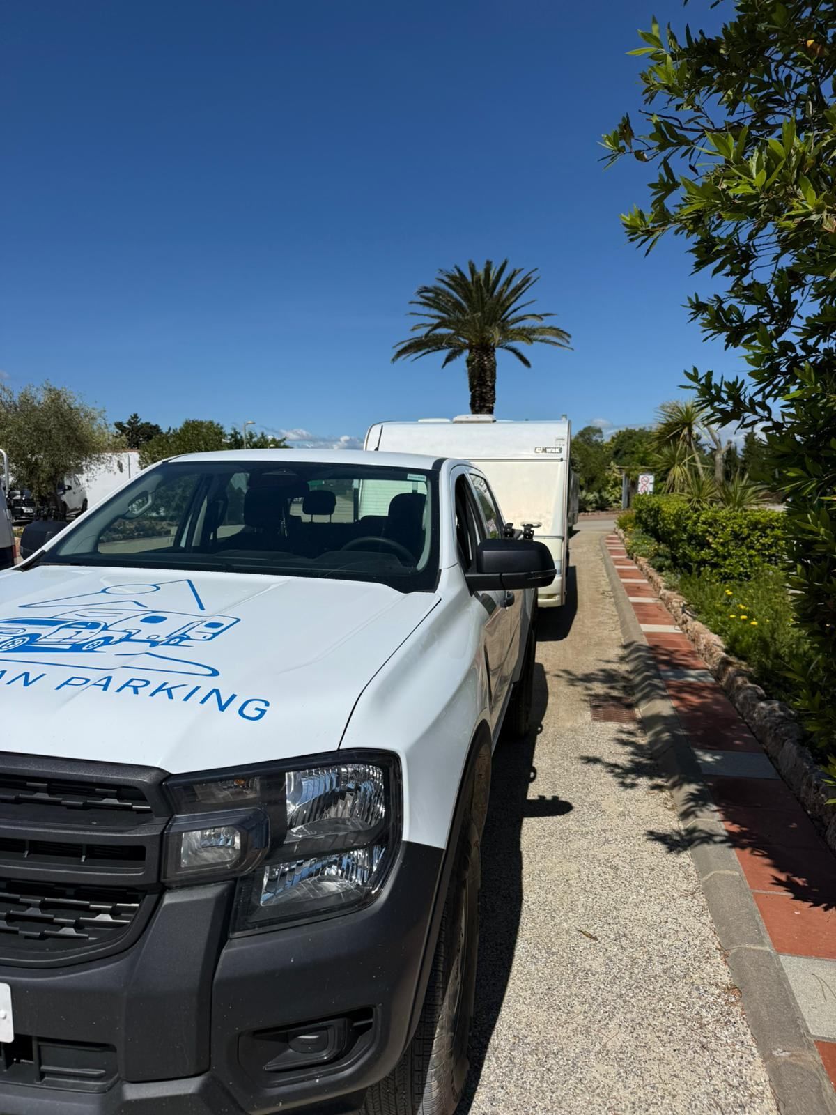 Punt Caravan Parking pickup with the logo on the bonnet, parked on a campsite path