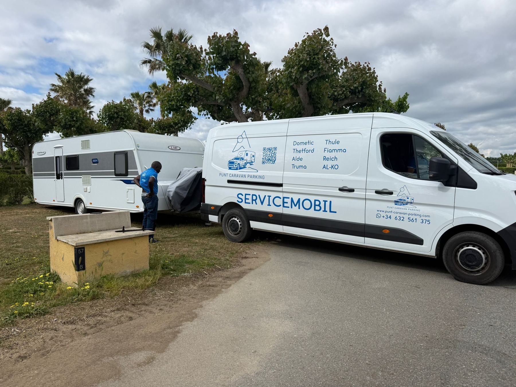 Mobile service van parked next to a caravan while a technician works on it