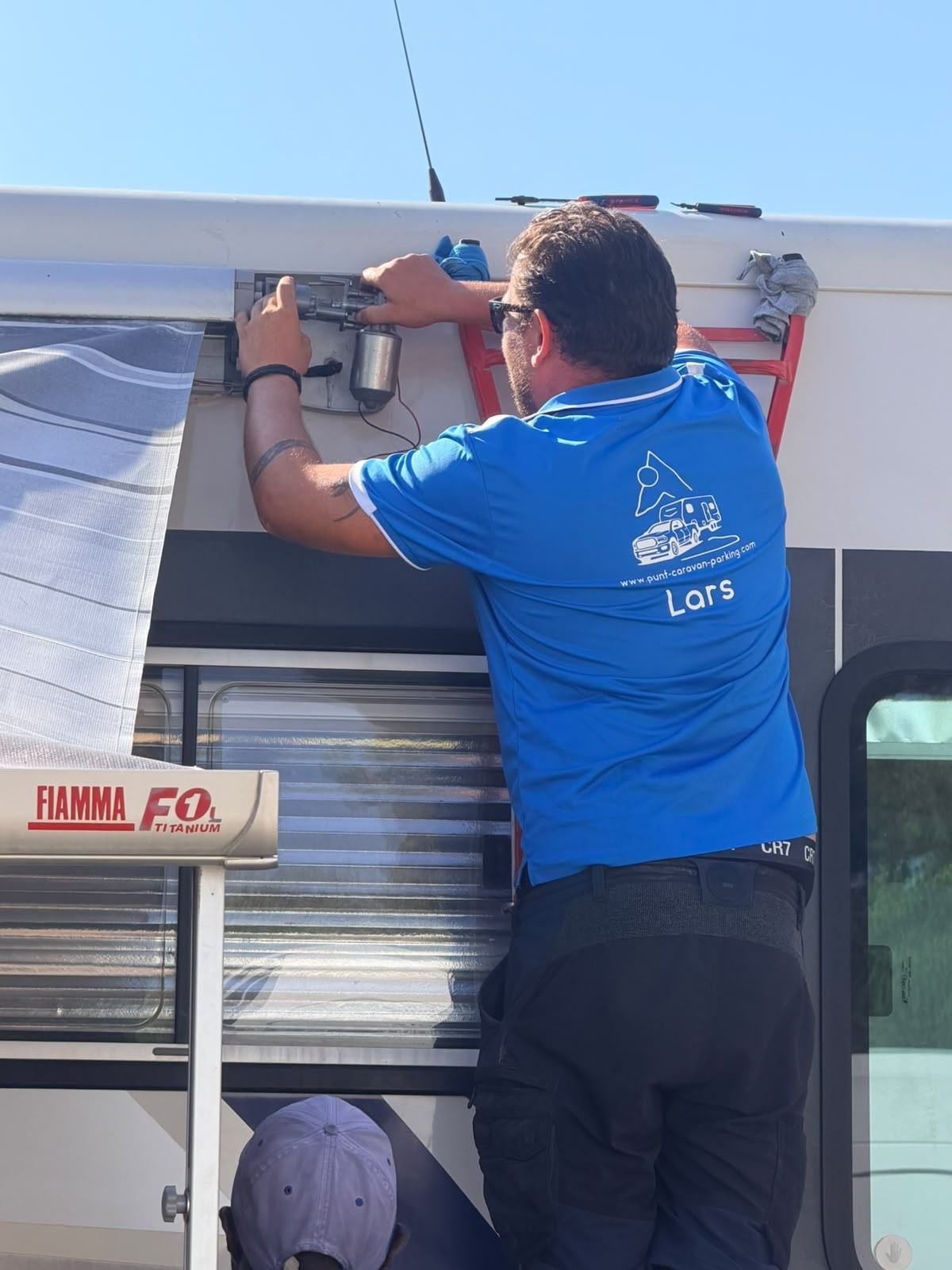 Lars fitting an awning rail to the side of a motorhome