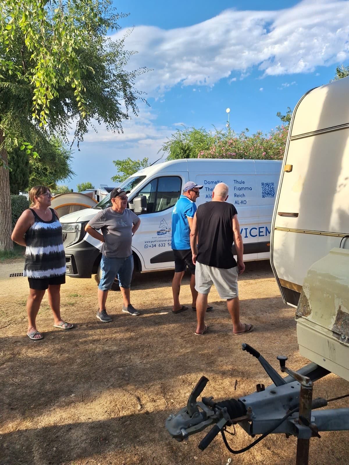 Caravan owners and the team chatting beside the service van
