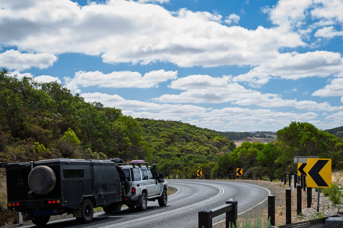 Four wheel drive truck towing a caravan on the scenic coastal drive, Great Ocean Road, Victoria, Australia